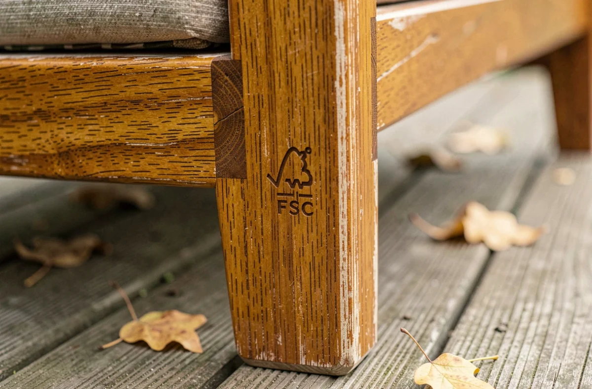 Détail du marquage certifié FSC sur le cadre en bois teck d'un fauteuil de jardin avec texture du grain visible